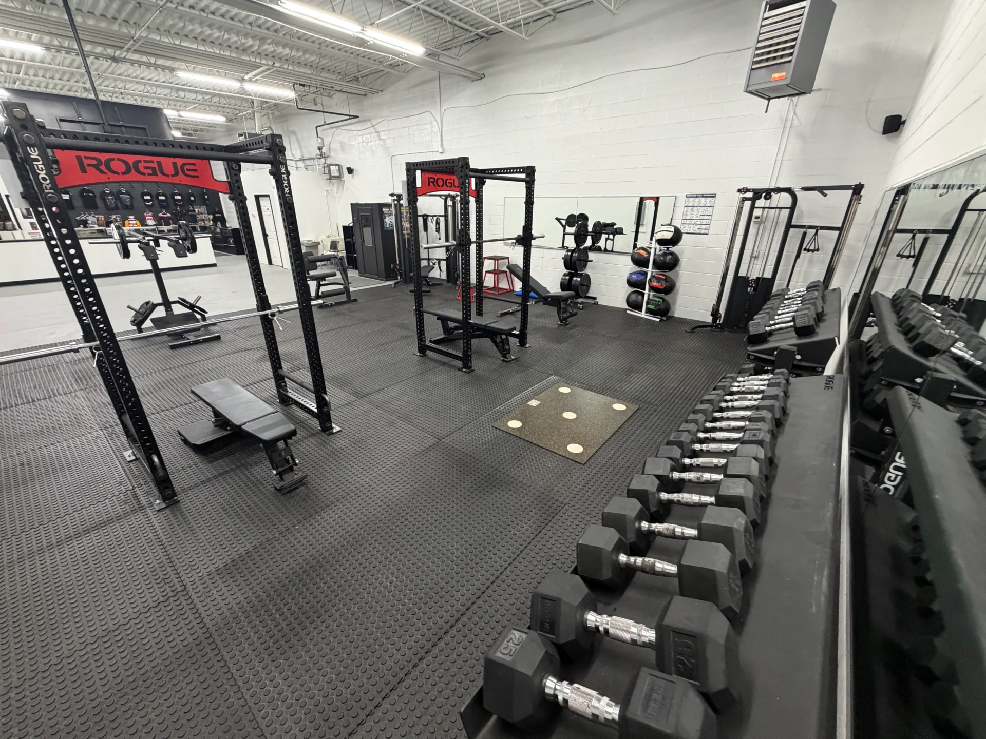 Gym with equipment and weight racks.